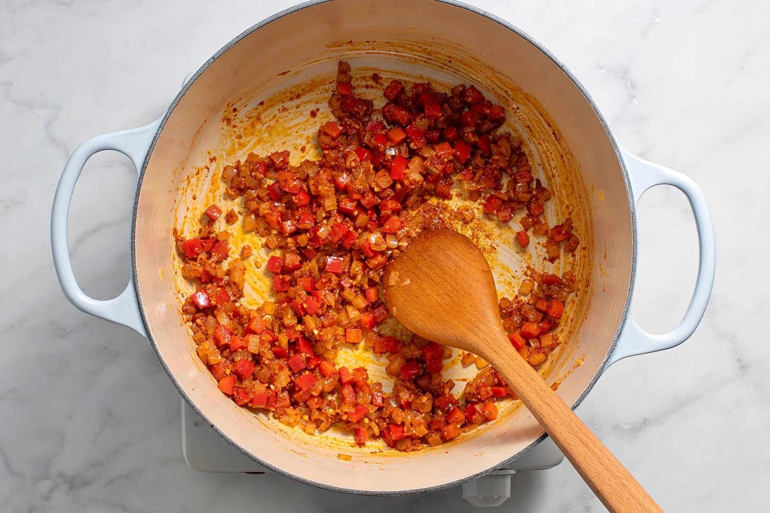 Onions and pepper with garlic, harissa, if using, paprika, cumin, and coriander in a pot