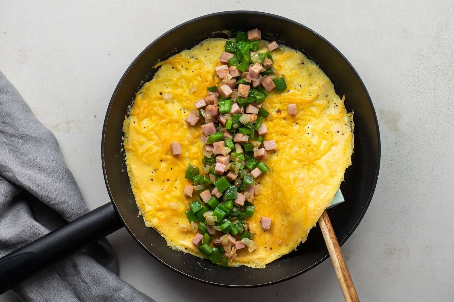 Relleno de jamón y pimiento extendido en el centro de la omelet