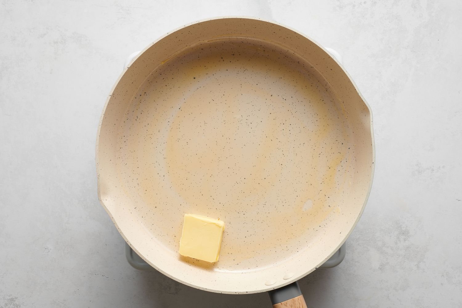 Un trozo de mantequilla en una sartén grande