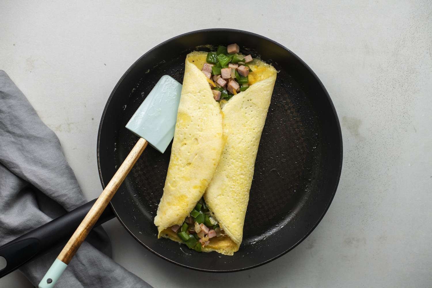 Lados de la omelet doblados sobre el relleno al centro