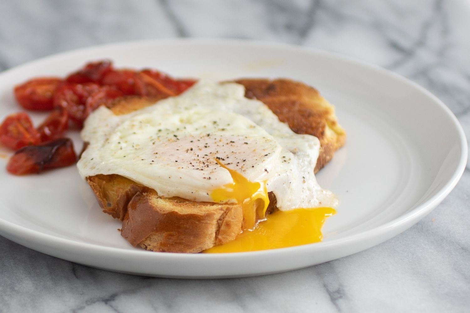 Huevo estrellado en una rebanada de pan tostado con la yema goteando