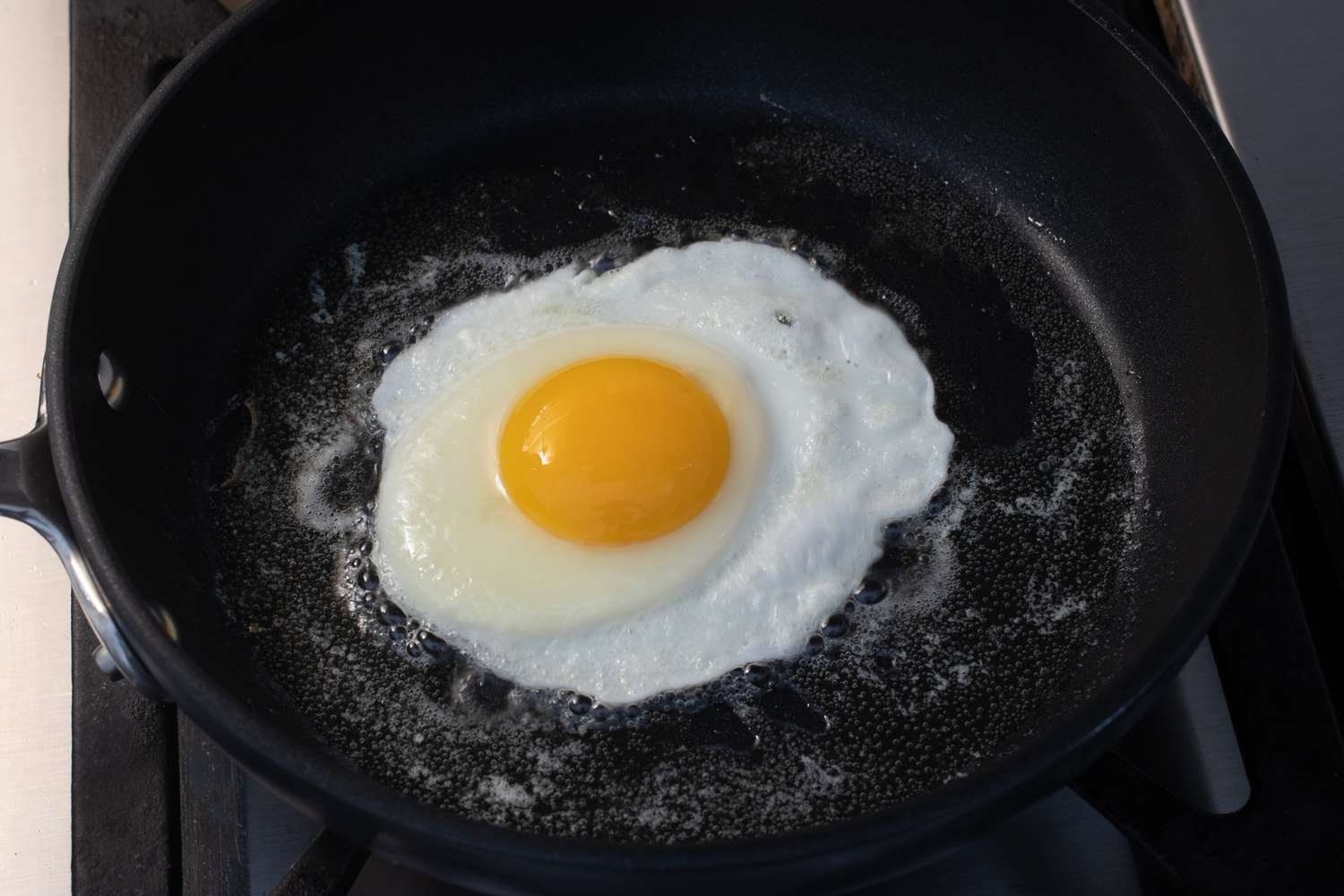 Huevo con la mayor parte de la clara firme en la sartén