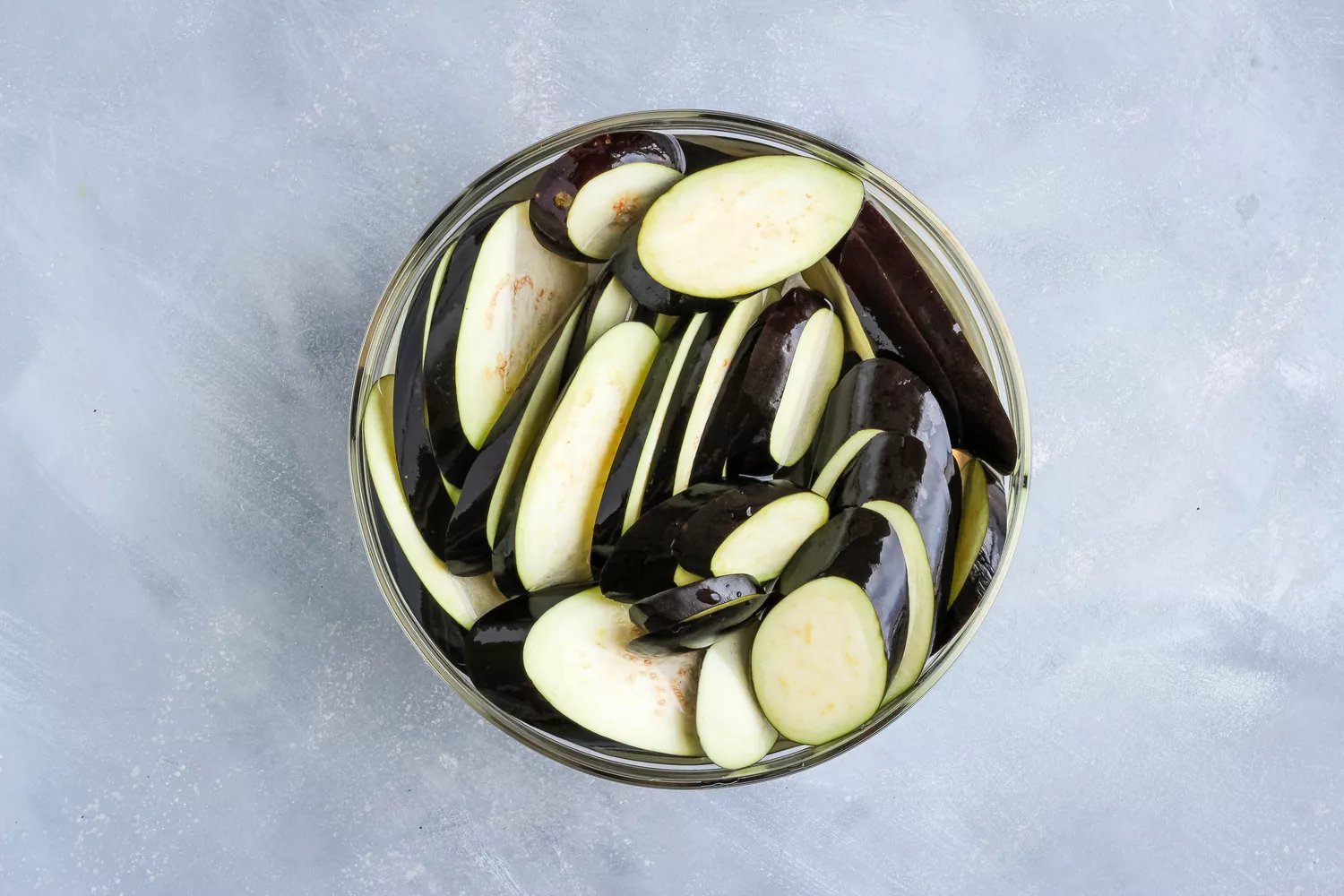 Fatias de berinjela em uma tigela de salmoura