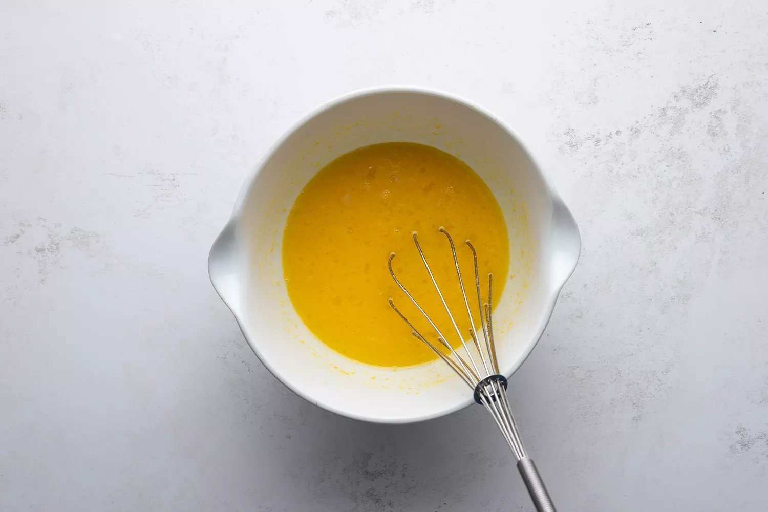 Mistura de Ovos, açúcares e limão com um batedor