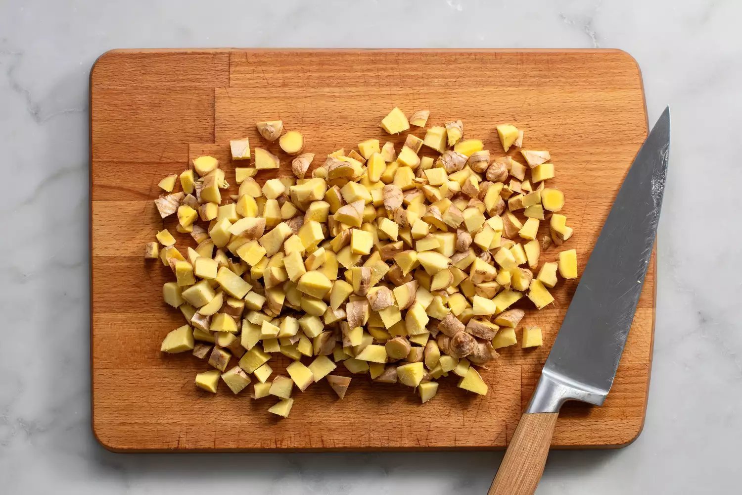 Gengibre picado em uma tábua com um faca