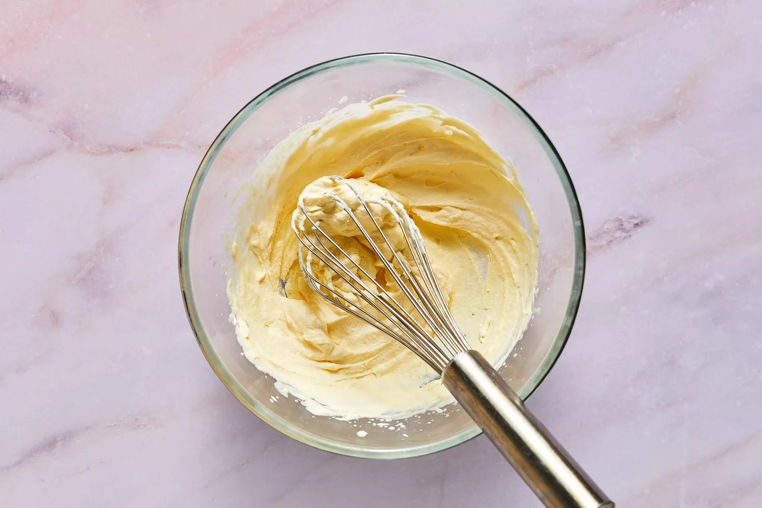 Uma tigela de chantilly com um batedor