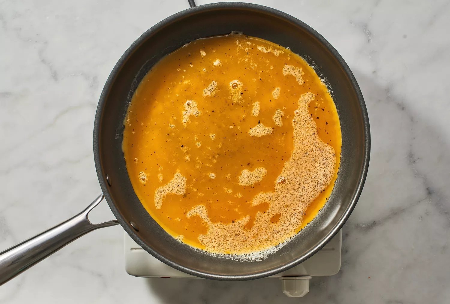 Uma panela com ovos batidos crus