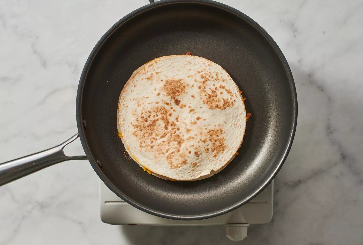 Uma quesadilla de queijo em uma frigideira