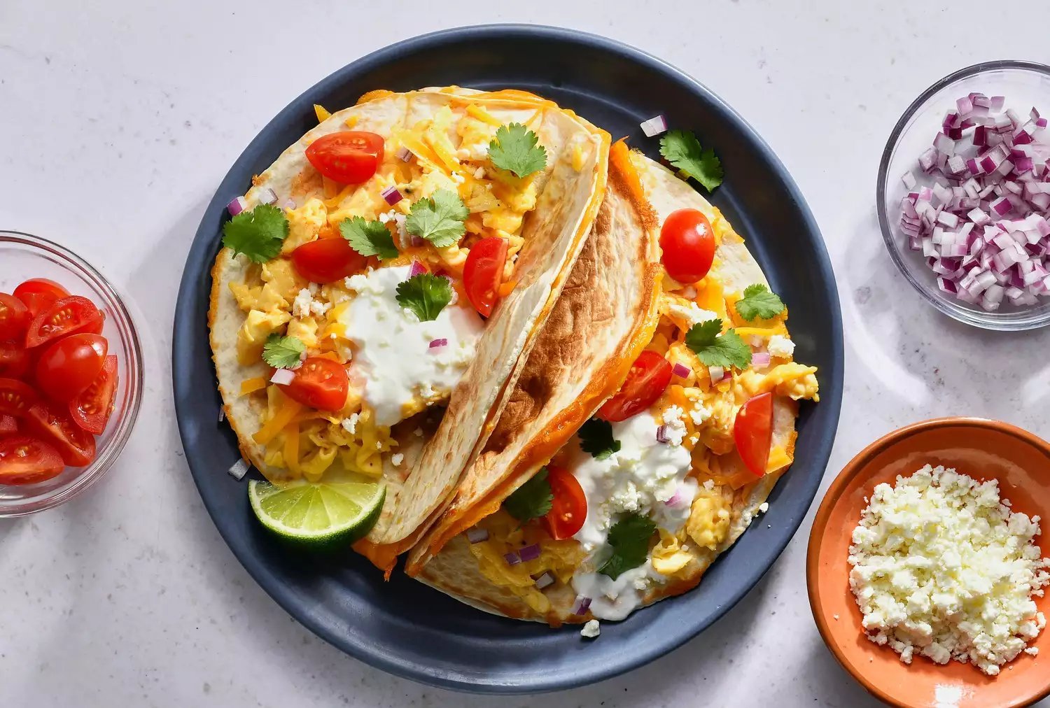 Tacos de café da manhã quesadilla cobertos com coentro, creme azedo e tomates