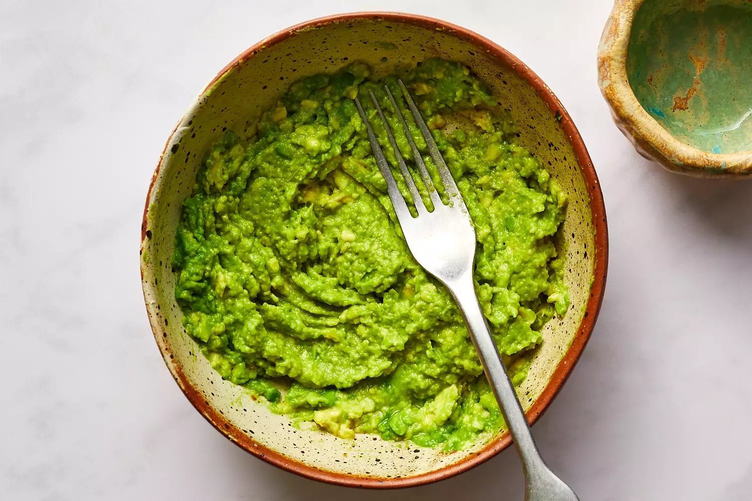 avocado mashed in bowl with a fork