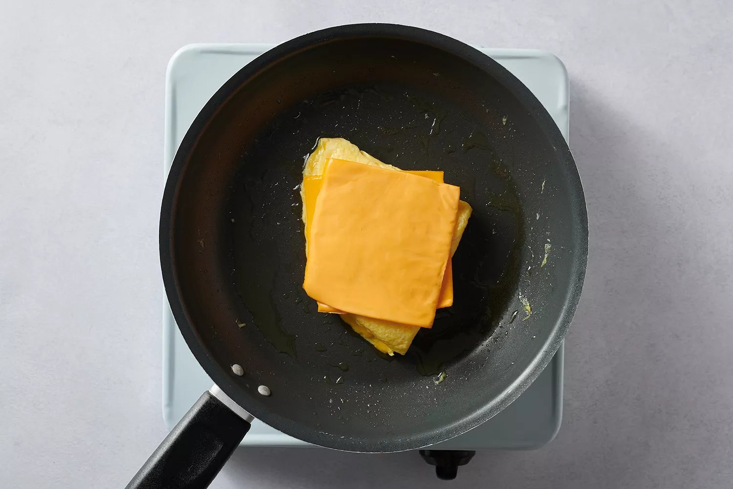 queijo sobre ovos na frigideira