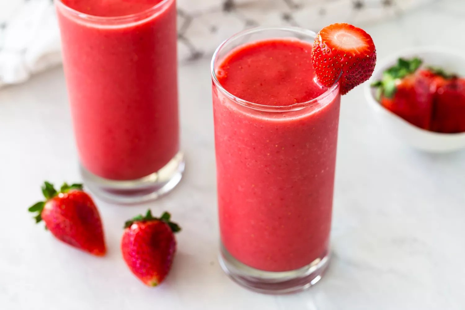 Smoothies de morango em dois copos enfeitados com morangos