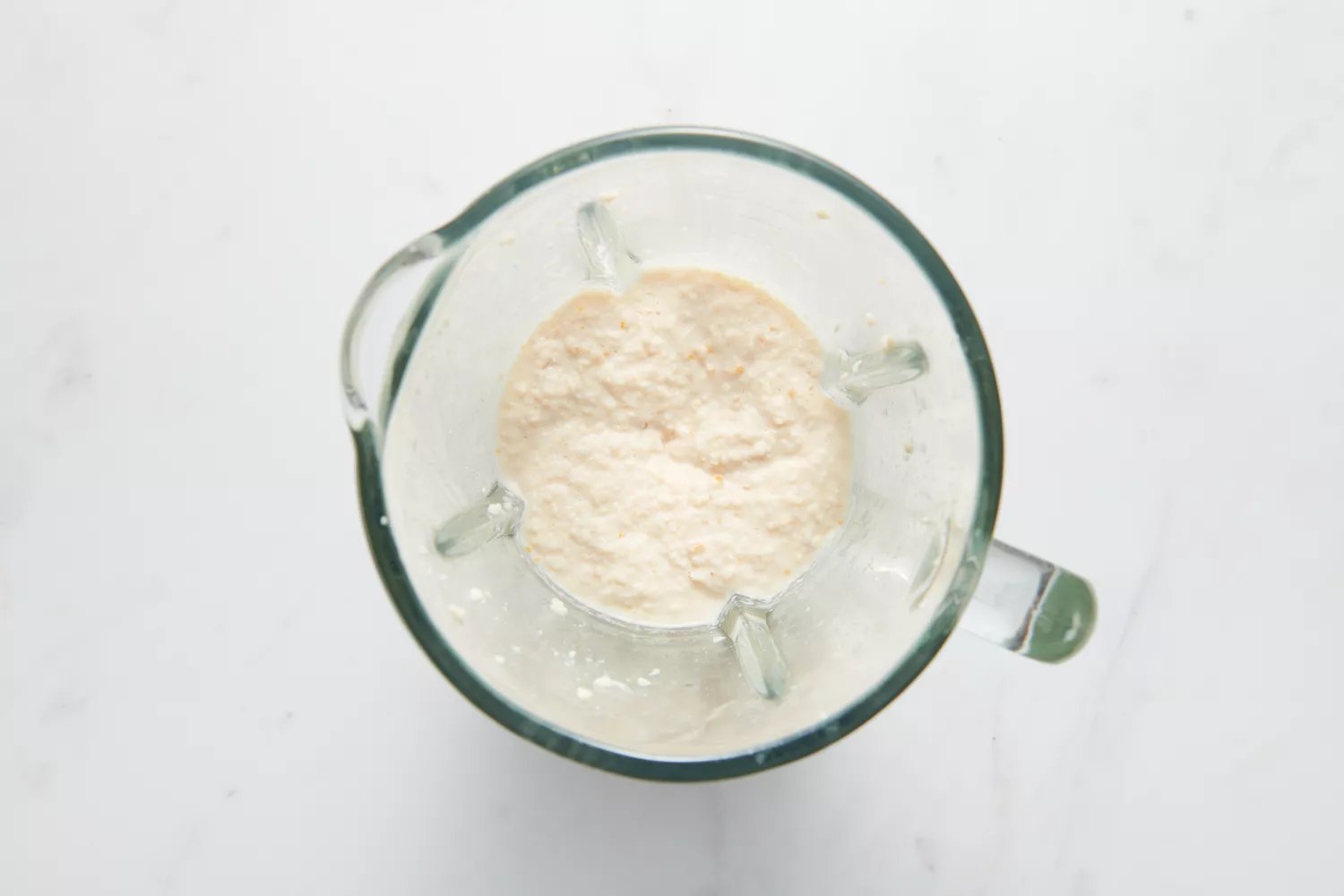 Um liquidificador com a massa de urad dal e feno-grego batida