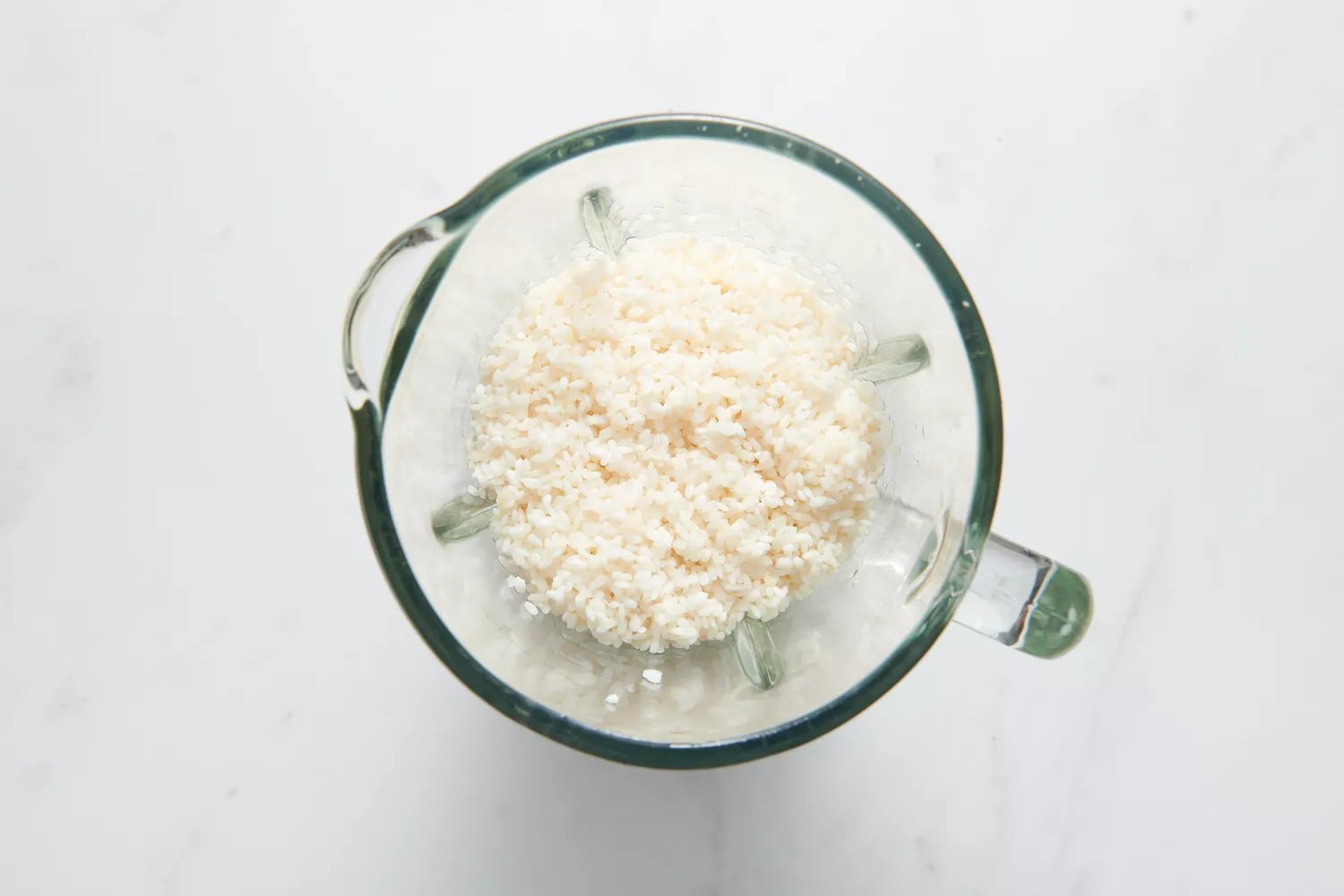 Um liquidificador com arroz Sona Masuri enxaguado